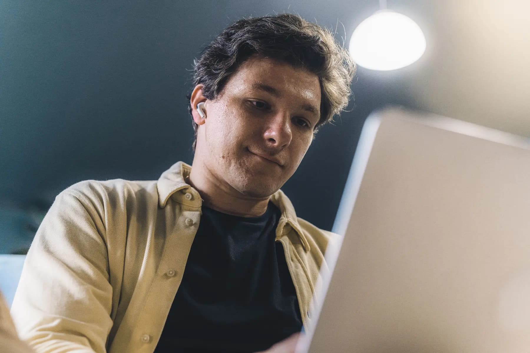 A founder reading on a laptop under a warm lamp